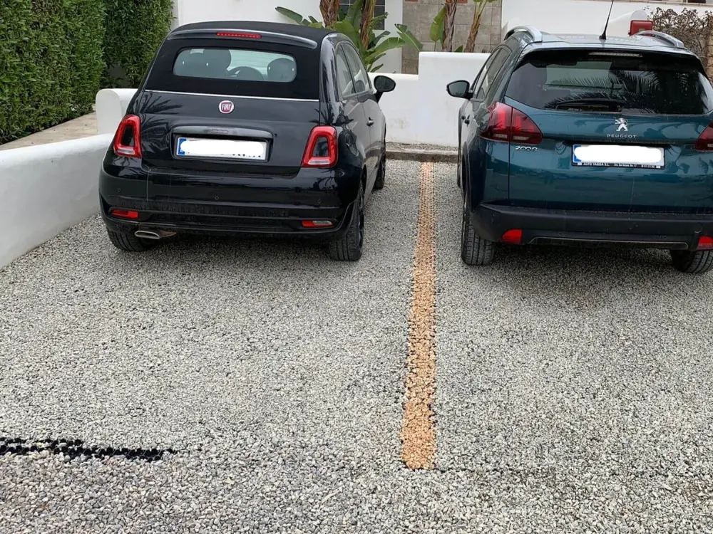 Estacionamiento residencial con gravilla clara, ideal para un estilo estético y funcional. La mejor gravilla para estacionamiento provista por Escombros Áridos.