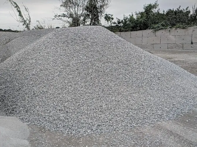 Pila de grava de construcción de alta calidad, acopiada y lista para la venta por metro cúbico en el patio de Escombros Áridos.