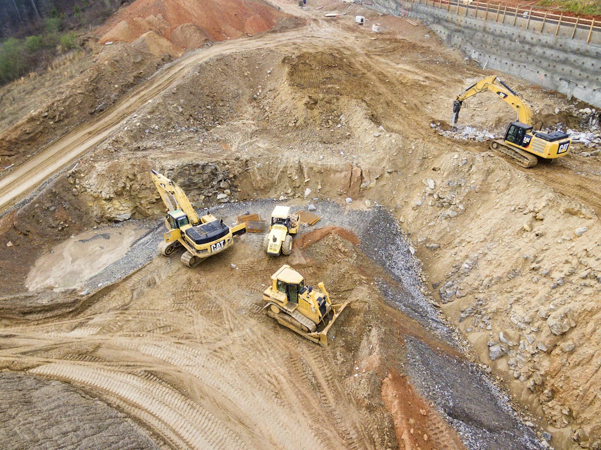 Pila de áridos y maquinaria en un sitio de construcción