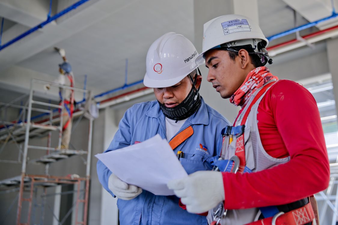 Trabajador de construcción con casco de seguridad en obra con materiales de remodelación