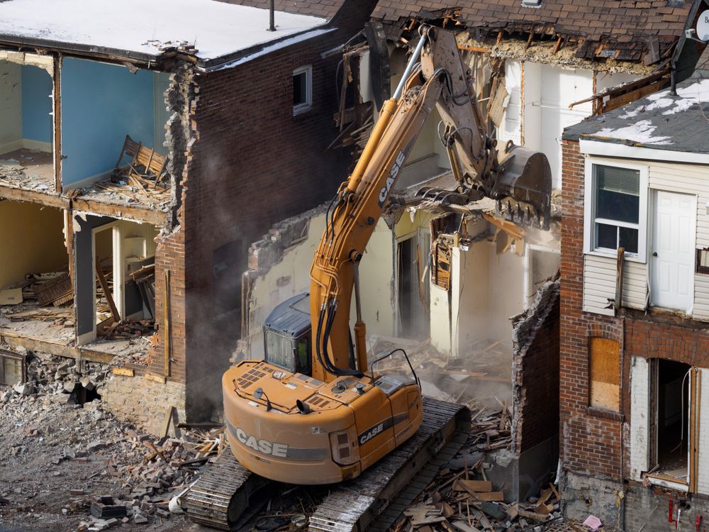 Excavadora en faena de demolición con escombros de construcción