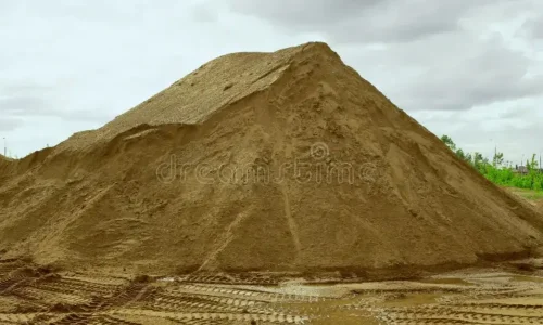 Gran montón de arena gruesa en el patio de Escombros Áridos, con huellas de camión en el suelo, listo para despacho en la Región Metropolitana.