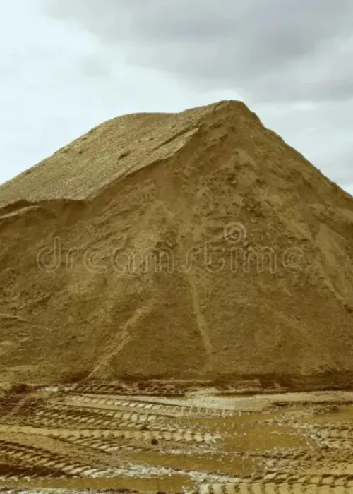 Gran montón de arena gruesa en el patio de Escombros Áridos, con huellas de camión en el suelo, listo para despacho en la Región Metropolitana.