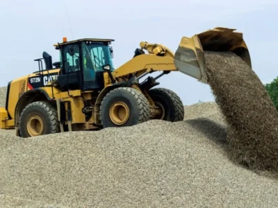 Cargador frontal amarillo de Escombros Áridos moviendo una gran cantidad de grava de construcción, demostrando nuestra capacidad para gestionar grandes volúmenes.