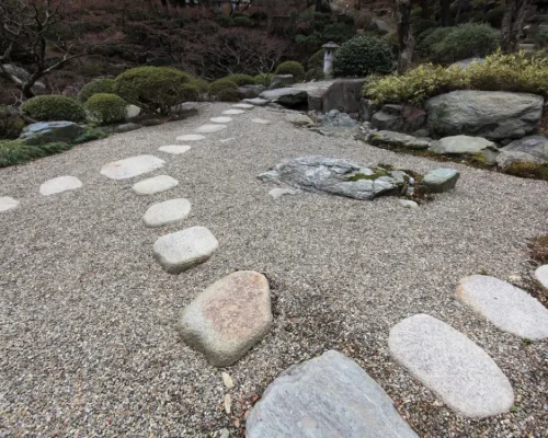Jardín zen o camino paisajístico con gravilla decorativa y grandes piedras de paso. Este árido es perfecto para senderos y diseño de jardines, disponible a la venta en Escombros Áridos.