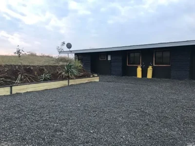 Estacionamiento con gravilla oscura de alta compactación, ideal para accesos de alto tránsito en viviendas. Material de calidad garantizado por Escombros Áridos.