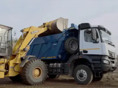 Cargador frontal en faena de movimiento de áridos, cargando material en un camión tolva de Escombros Áridos en Santiago.